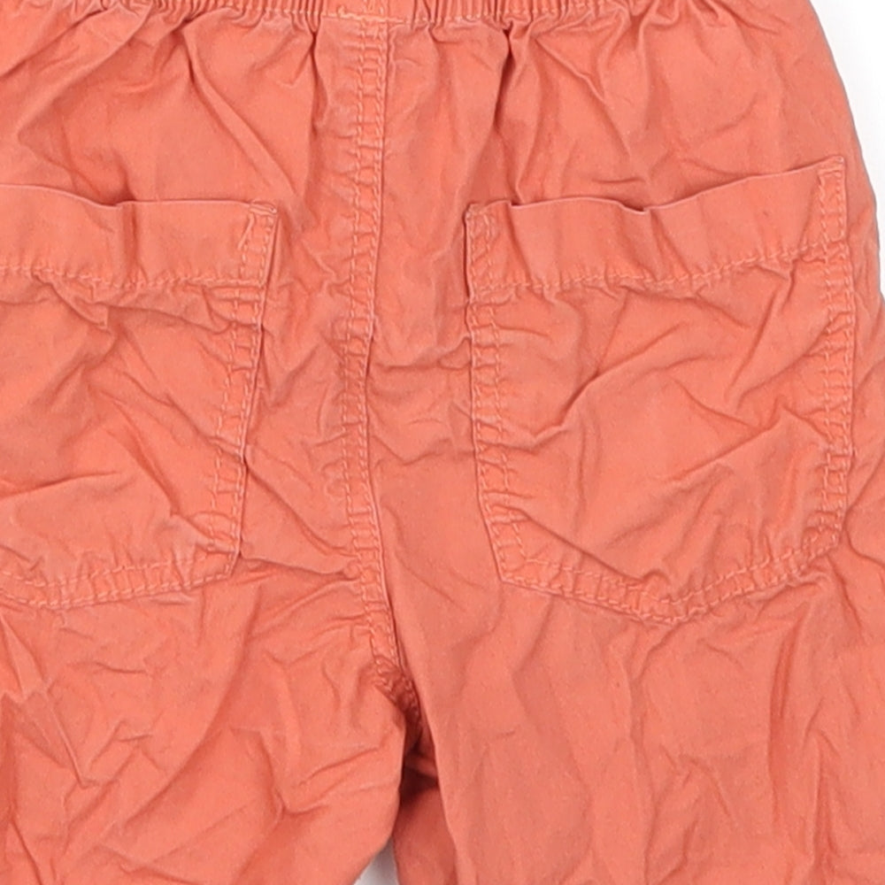 Brand and care label for Tu boys’ orange cargo trousers, size 18-24, months