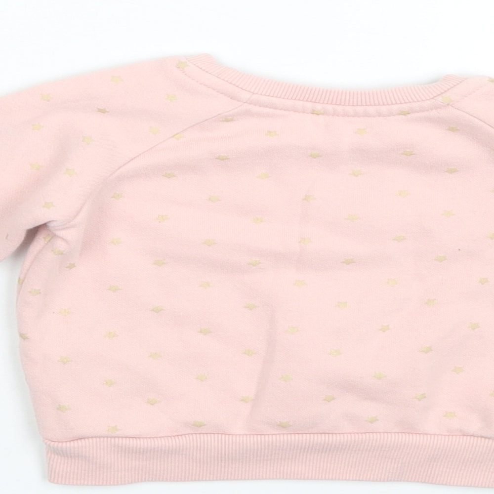 Brand and care label for Primark girls’ pink polka dot jumper, size 9-12, months