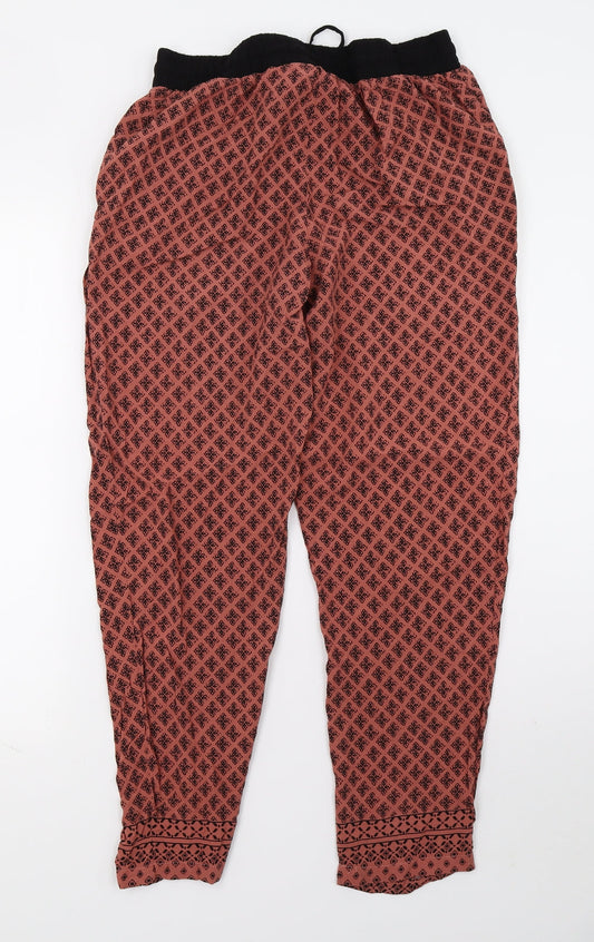 Back view of Newlook women’s orange floral trousers, size M, 26-inch leg