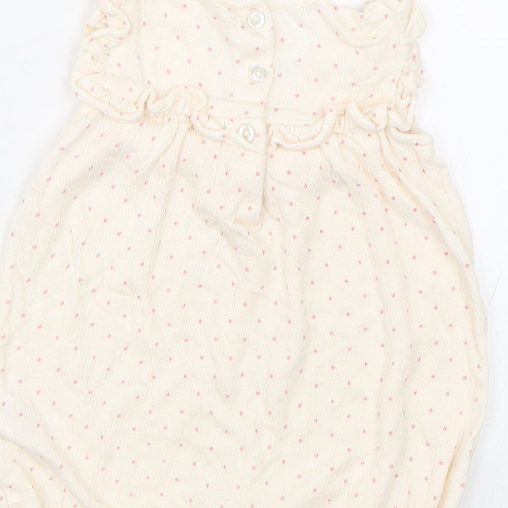 Brand and care label for George girls’ beige spotted babygrow one-piece, size 3-6, months