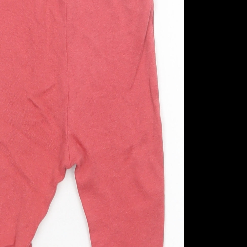 Brand and care label for Nutmeg girls’ pink sweatpants, size 3-6, months