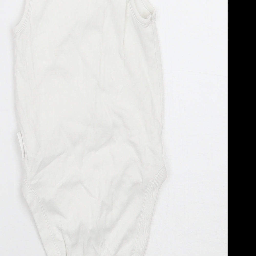 Brand and care label for Next boys’ white babygrow one-piece, size 6-9, months