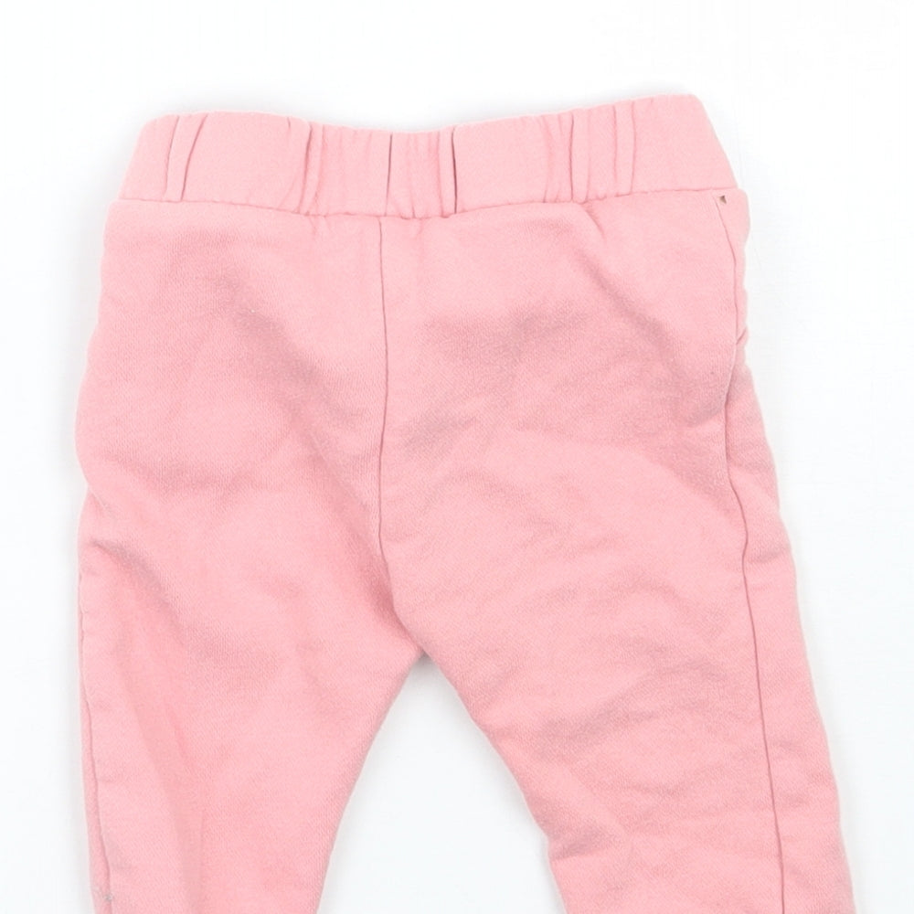 Brand and care label for F&F girls’ pink sweatpants, size 3-6, months