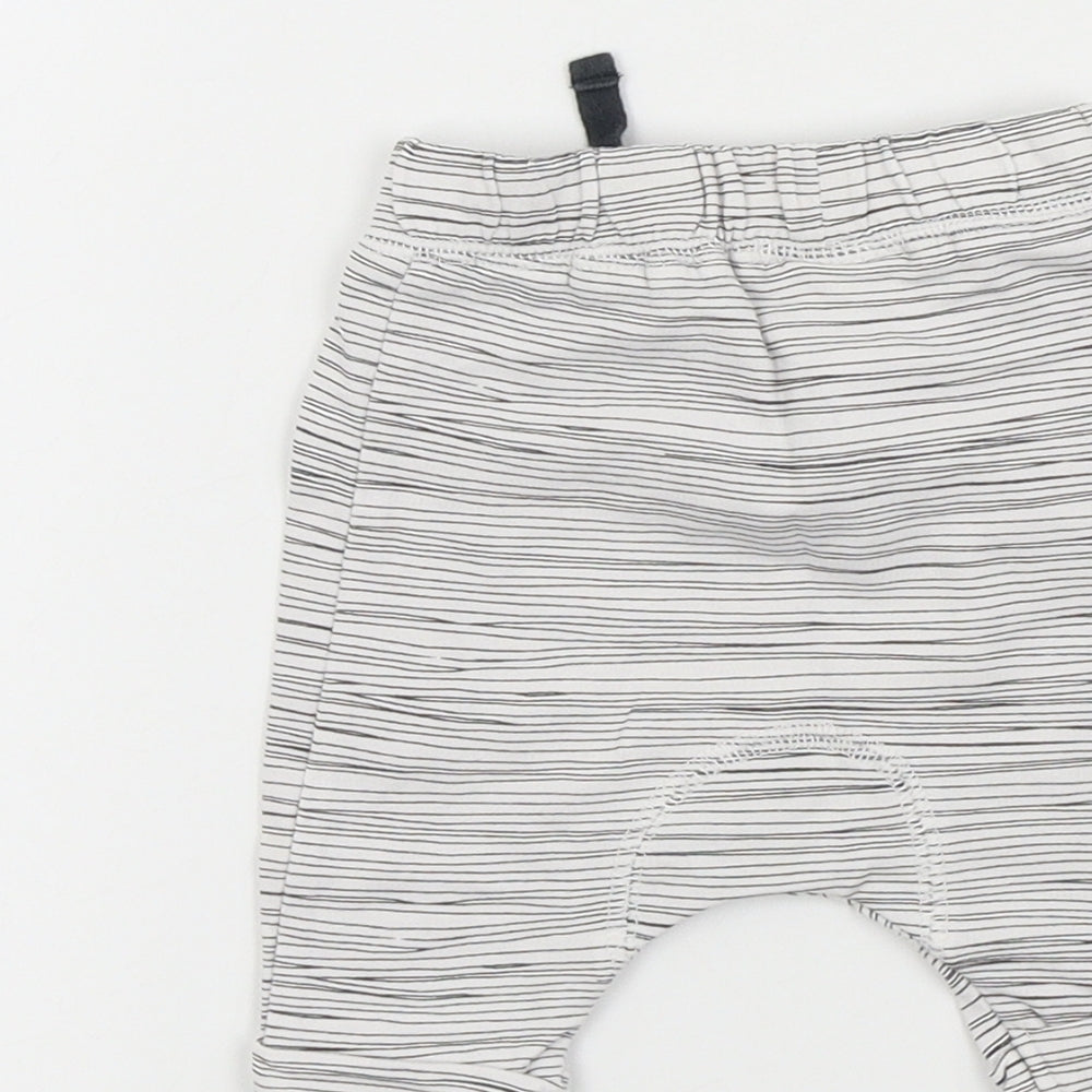 Brand and care label for Next Baby White Jogger Trousers, size 9-12, Months