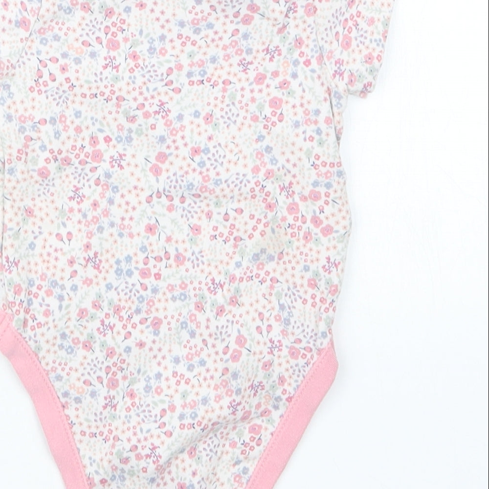 Brand and care label for George girls’ pink floral babygrow one-piece, size 3-6, months