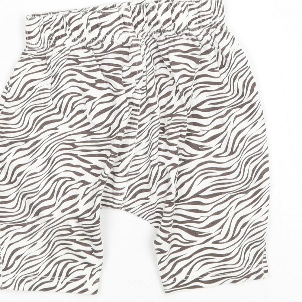 Brand and care label for Matalan girls’ white animal print sweatpants, size 9-12, months