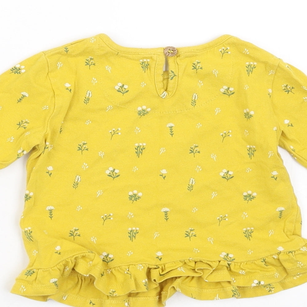 Brand and care label for Mini Club girls’ yellow floral basic t-shirt, size 6-9, months