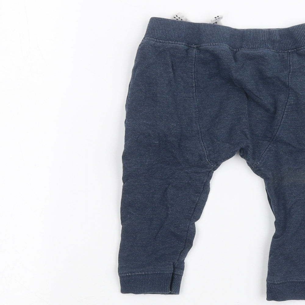 Brand and care label for Nutmeg Baby Blue sweatpants, size 9-12, Months