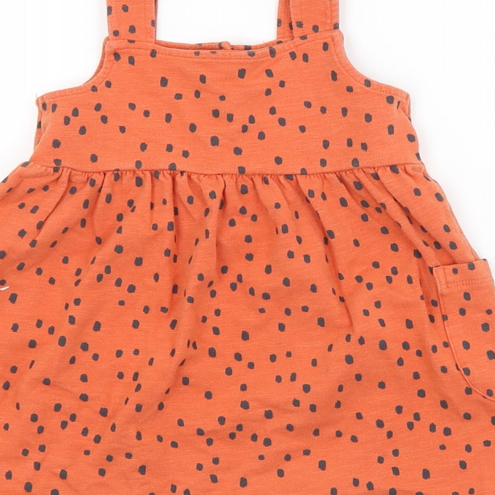 Brand and care label for Nutmeg boys’ orange spotted pinafore/dungaree dress, size 12-18, months