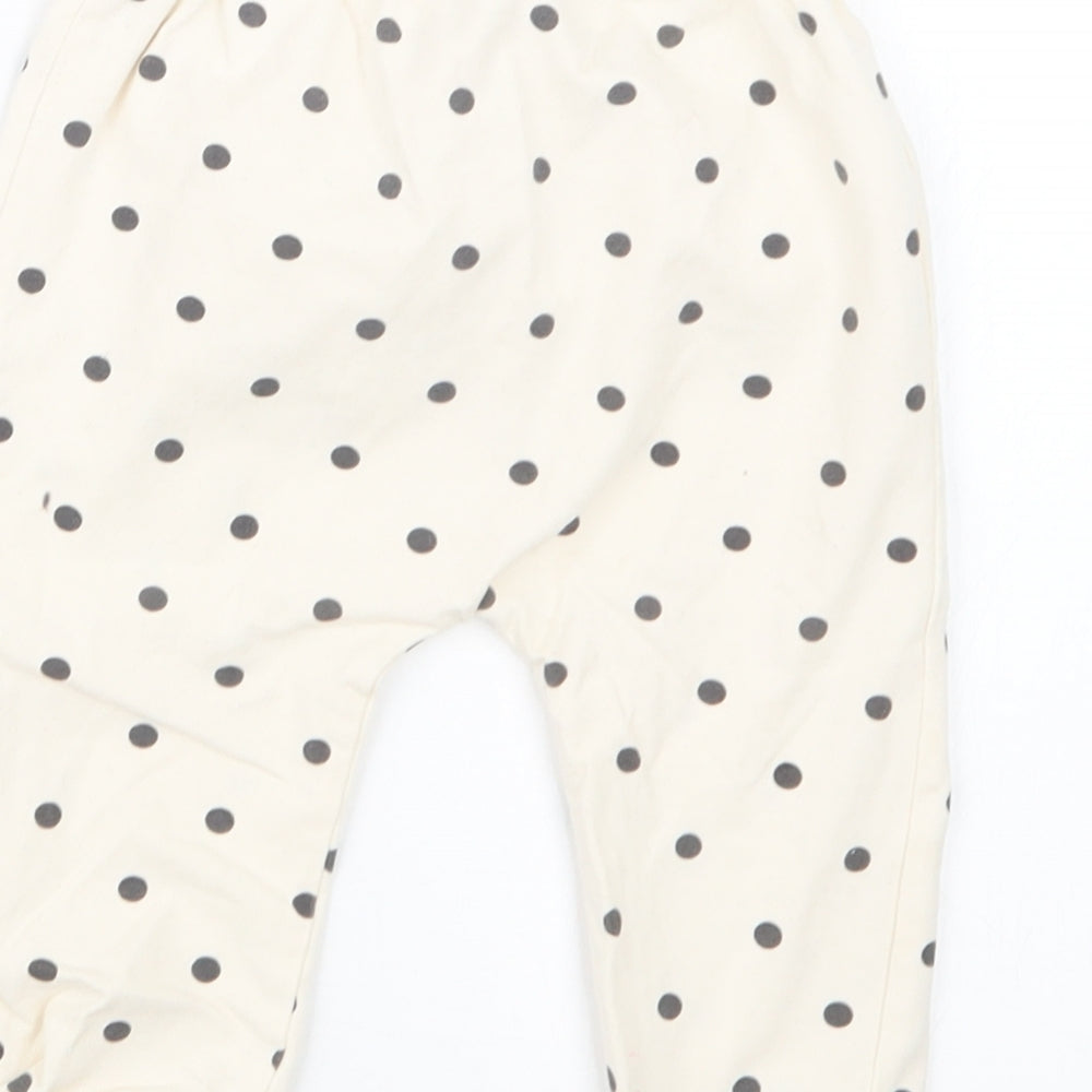 Brand and care label for Tu girls’ ivory polka dot capri trousers, size 6-9, months