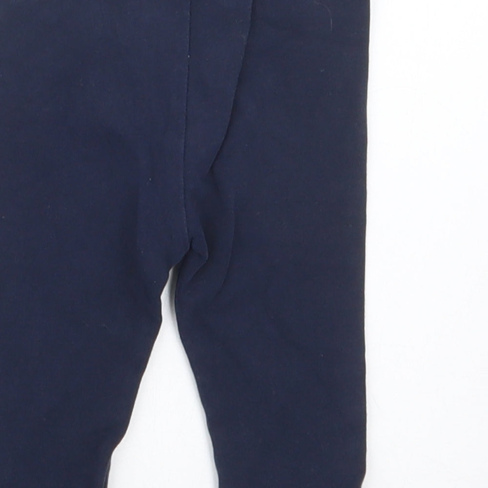 Brand and care label for Next girls’ blue capri trousers, size 6-9, months