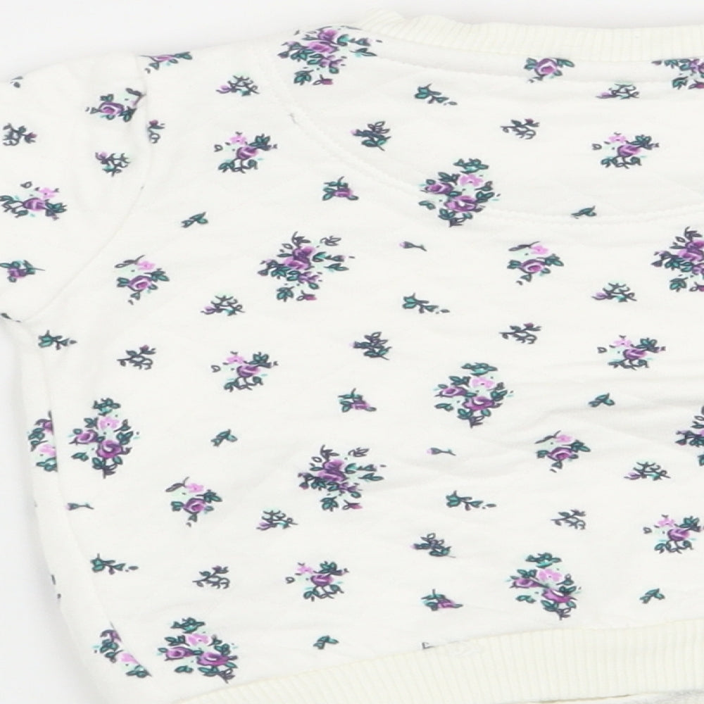 Brand and care label for F&F girls’ white floral jumper, size 0-3, months
