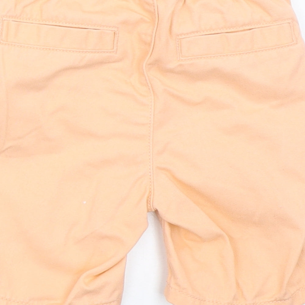 Brand and care label for Nutmeg boys’ orange cropped trousers, size 12-18, months