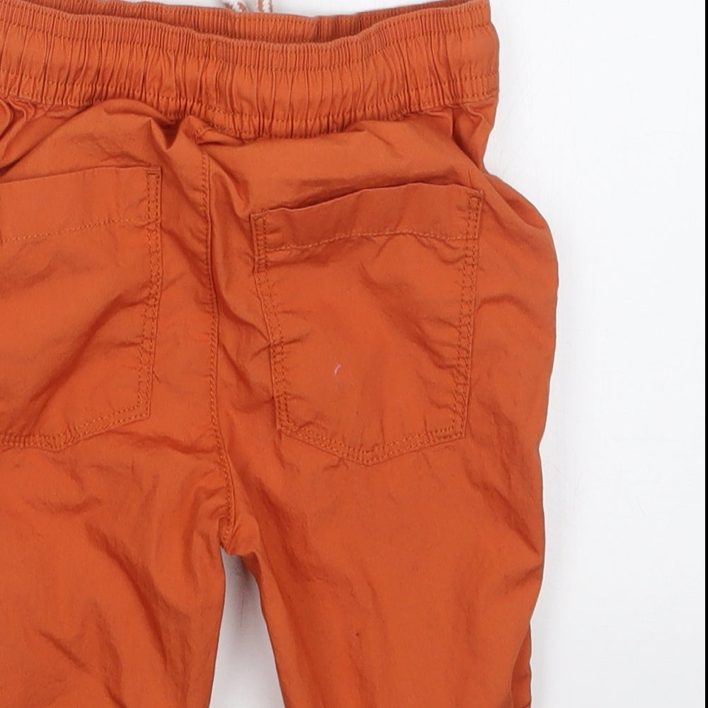 Brand and care label for TU boys’ orange cropped trousers, size 3-4, years