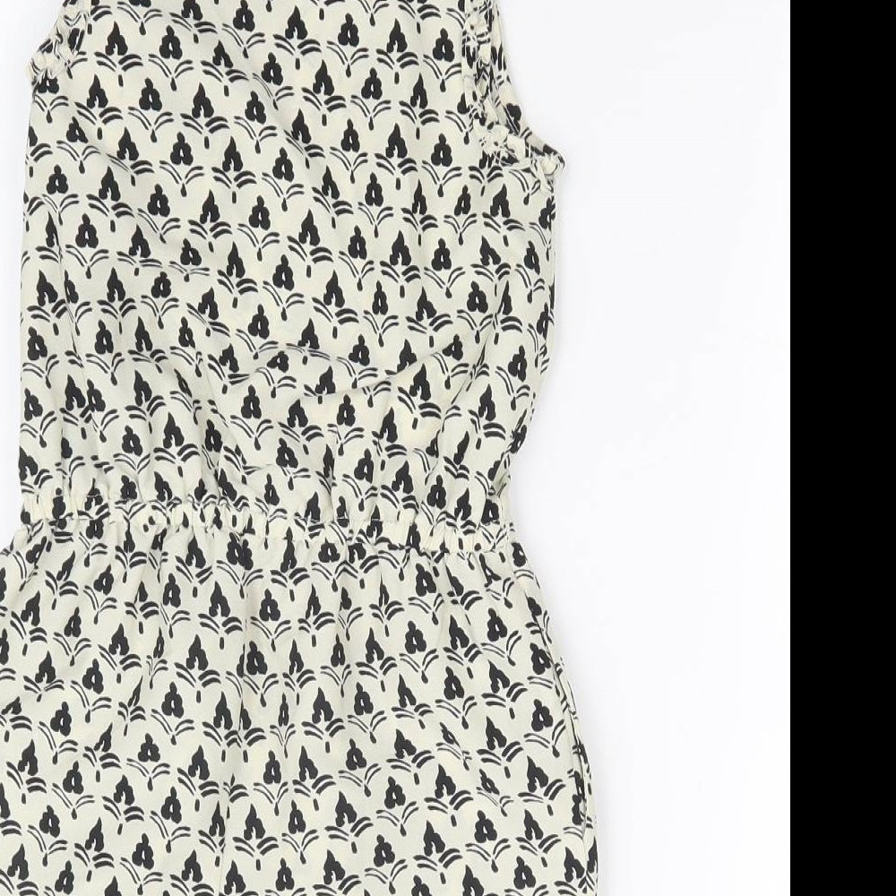 Brand and care label for Next girls’ multicoloured geometric playsuit one-piece, size 4, years