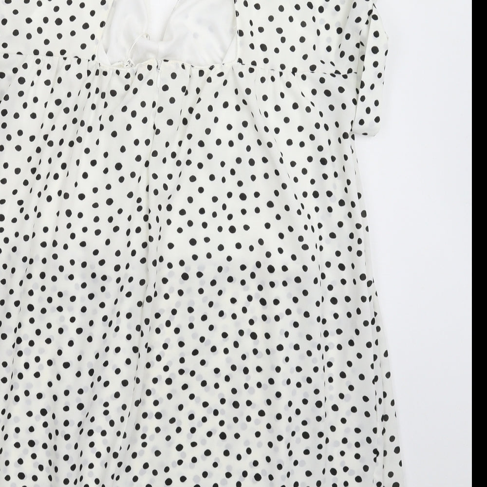 Brand and care label for Kilky women’s white polka dot mini, size M