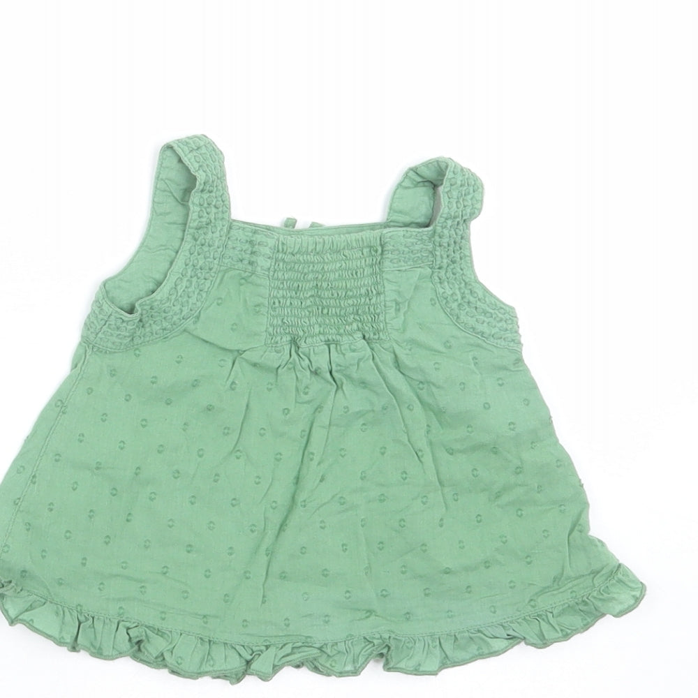 Brand and care label for Monsoon girls’ green geometric basic blouse, size 3-6, months