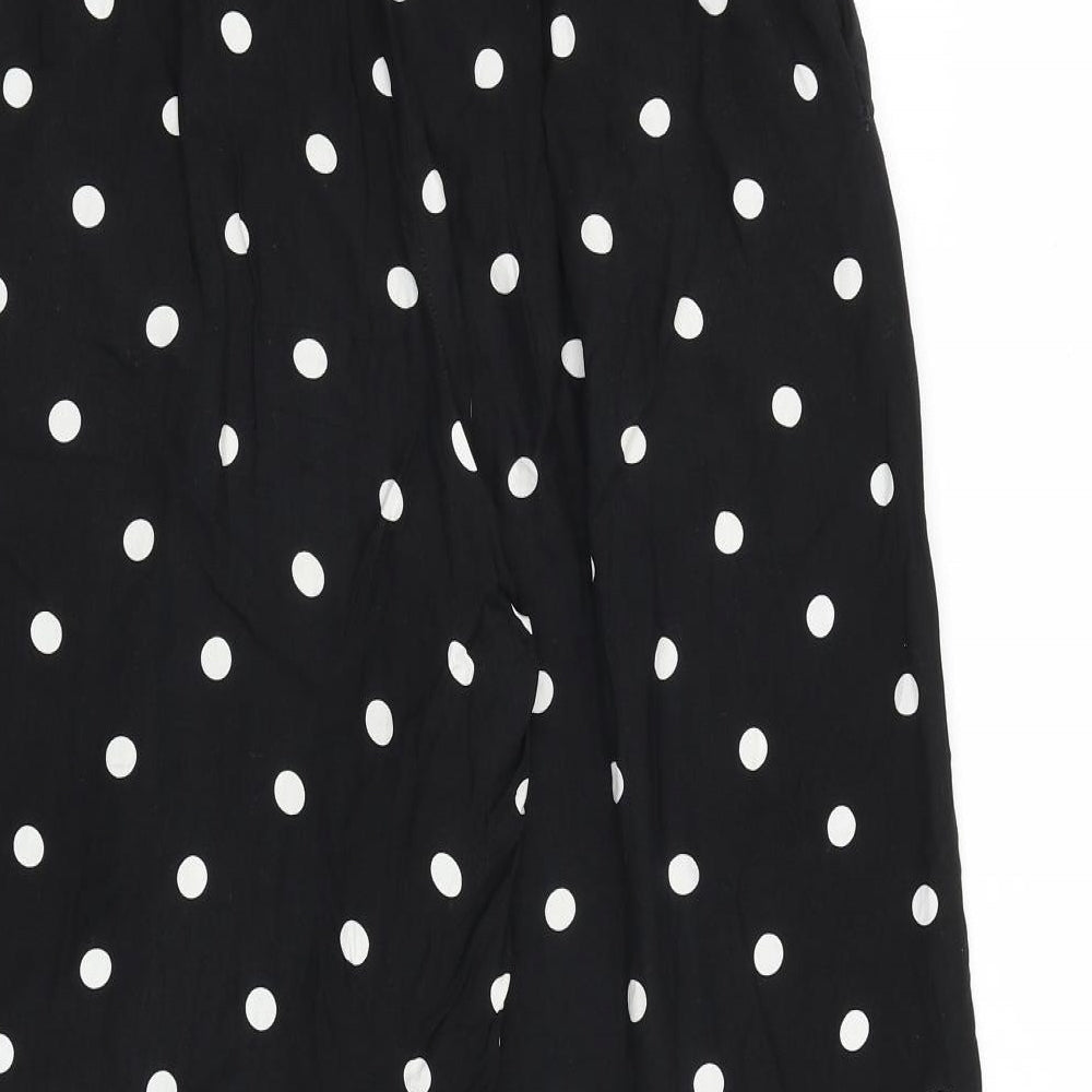 Brand and care label for Urban Outfitters women’s black polka dot viscose trousers, size UK 26, in regular buckle