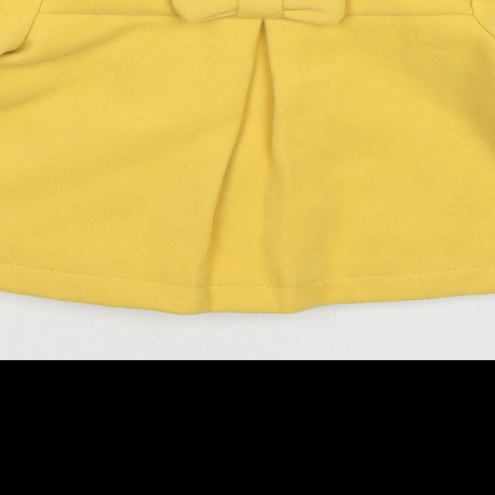 Brand and care label for Maxx girls’ yellow pea coat coat, size 12, months button