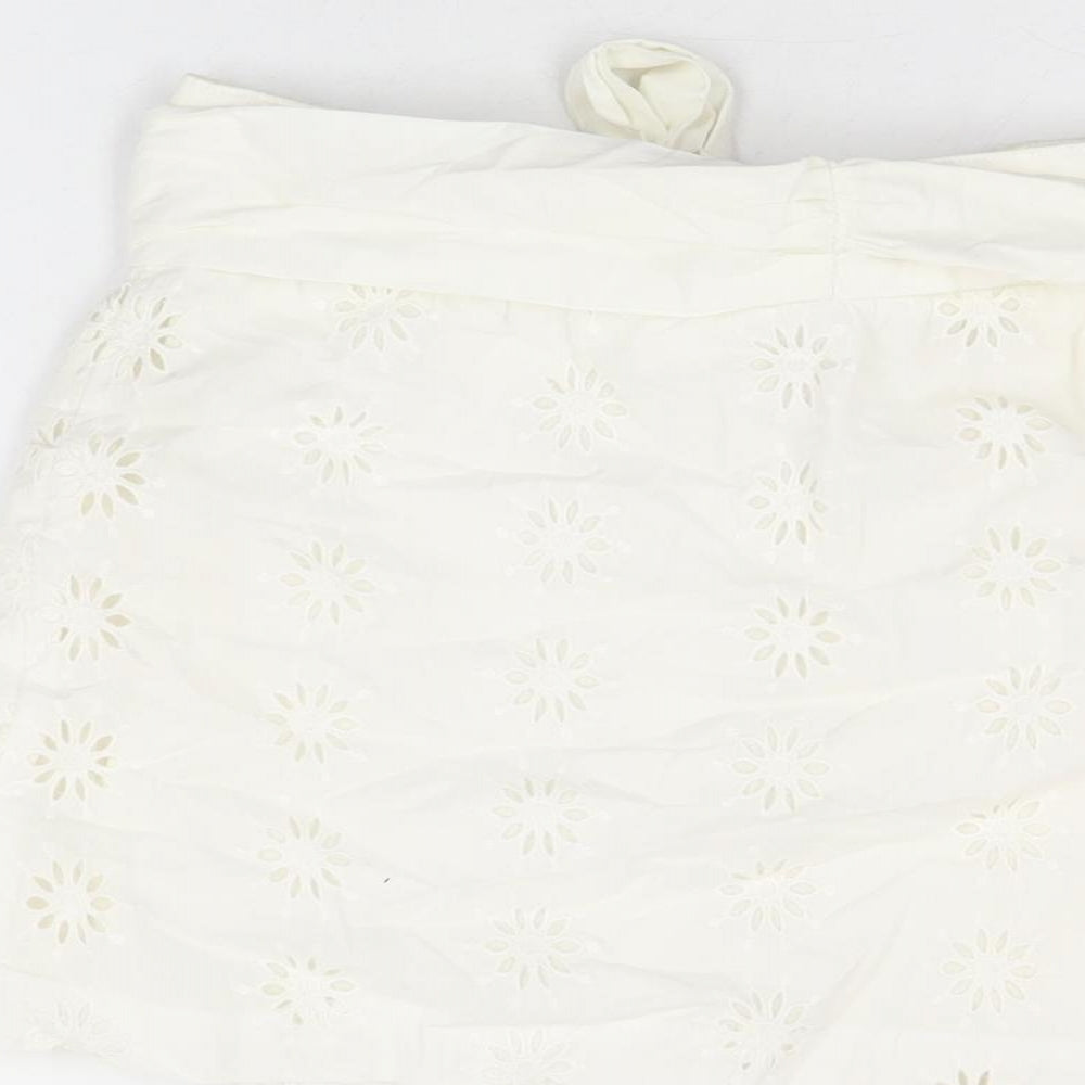 Brand and care label for ASOS women’s white floral cotton mini skirt, size UK 8, button
