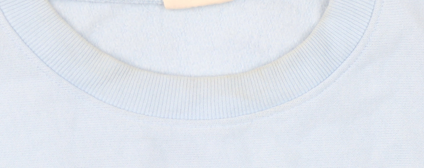 Brand and care label for Champion unisex blue sweatshirt, size 6, lightweight casual