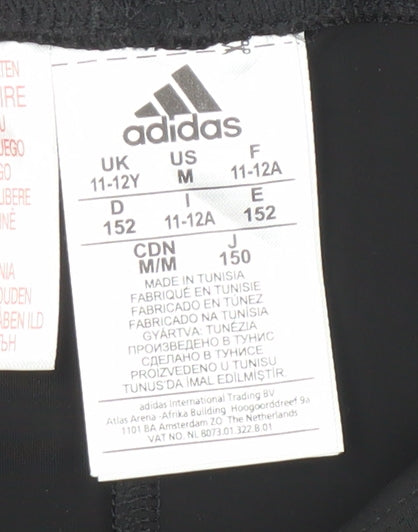 Brand and care label for Adidas girls’ black athletic shorts, size 11