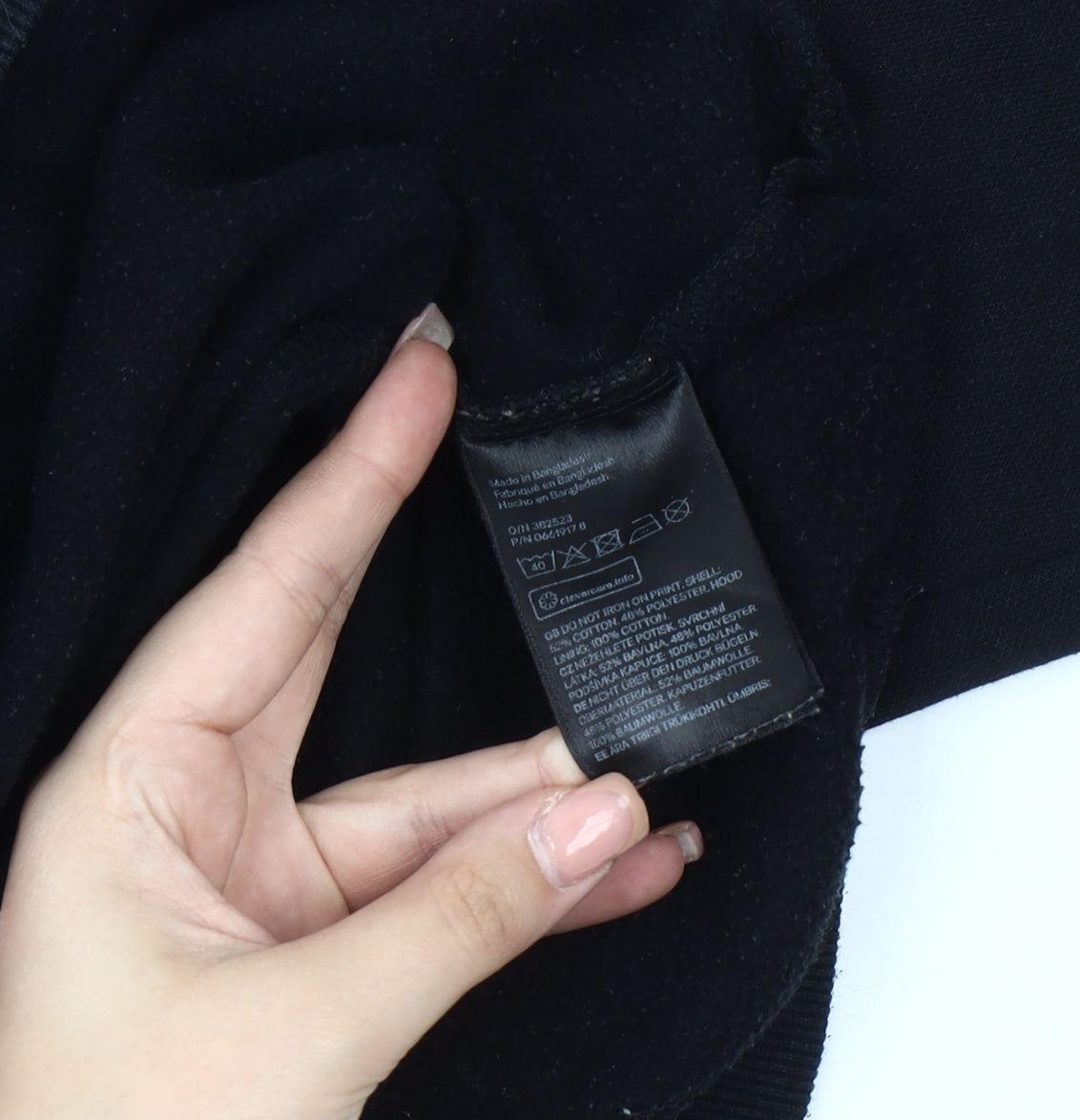 Brand and care label for H&M unisex black pullover hoodie, size 12