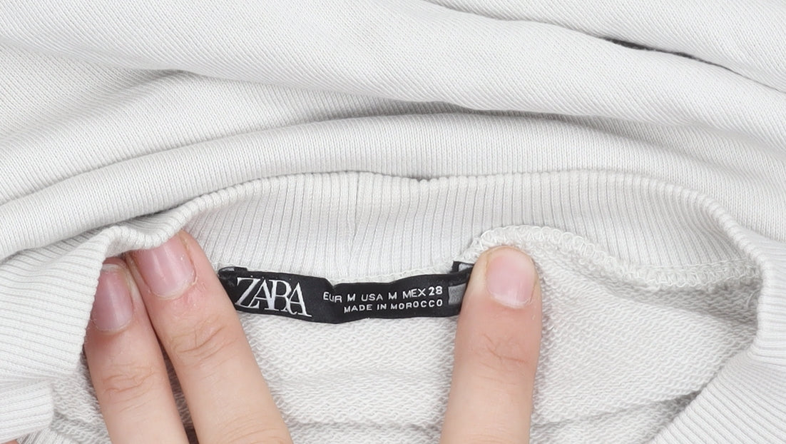 Close-up detail of Zara unisex white graphic sweatshirt, size 12