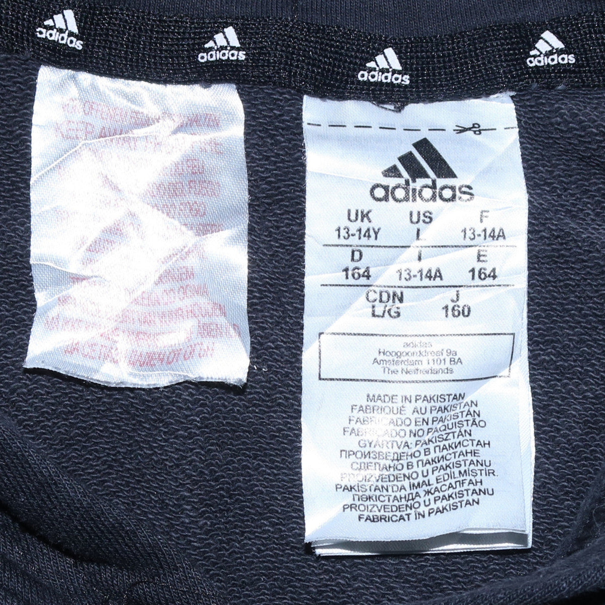 Close-up detail of Adidas boys’ black pullover hoodie 13-14 years classic logo cotton blend