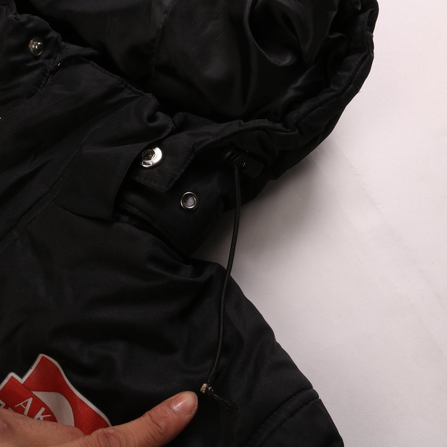 Brand and care label for Umbro boys’ black 13-14 years hooded long puffer coat football team jacket