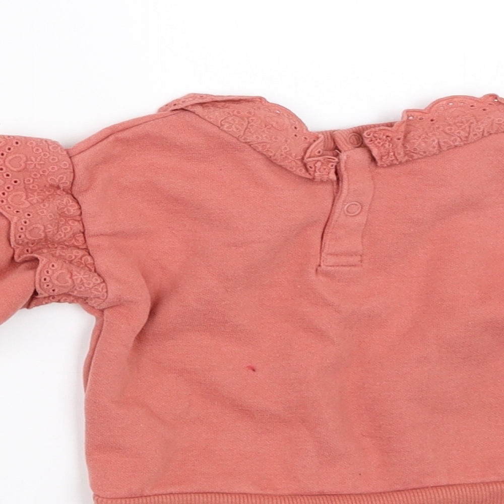 Brand and care label for Primark girls’ orange jumper, size 6-9, months