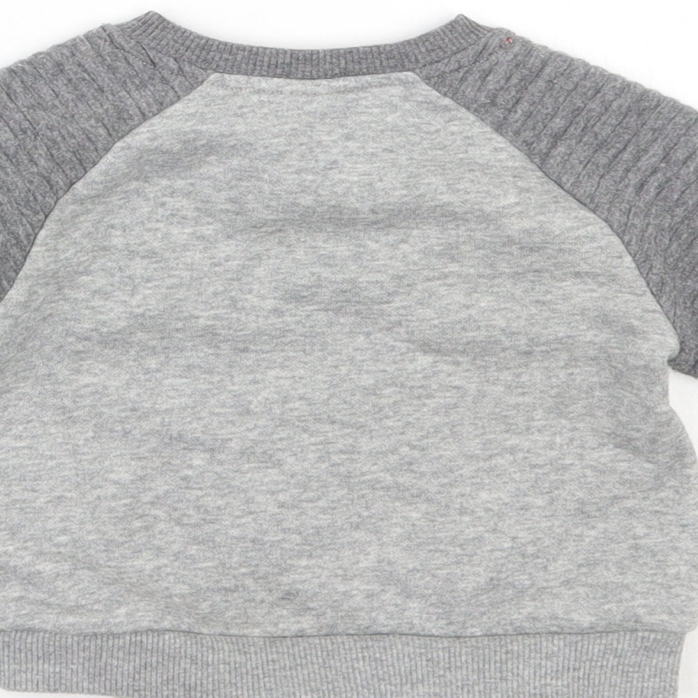 Brand and care label for Disney girls’ grey jumper, size 6-9, months