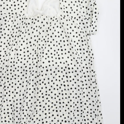 Brand and care label for Kilky women’s white polka dot mini, size M