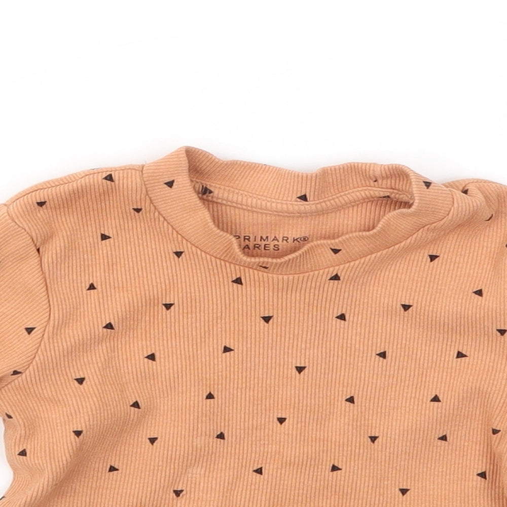 Close-up detail of Primark girls’ orange geometric basic t-shirt, size 9-12, months