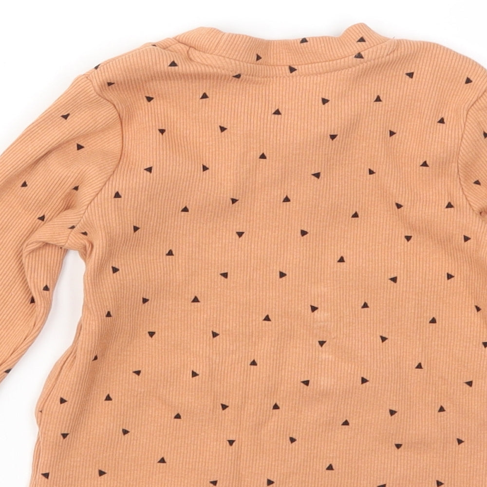 Brand and care label for Primark girls’ orange geometric basic t-shirt, size 9-12, months