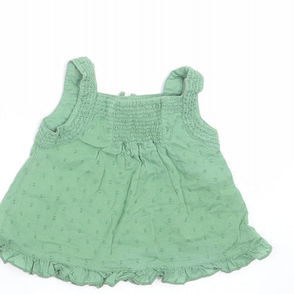 Brand and care label for Monsoon girls’ green geometric basic blouse, size 3-6, months