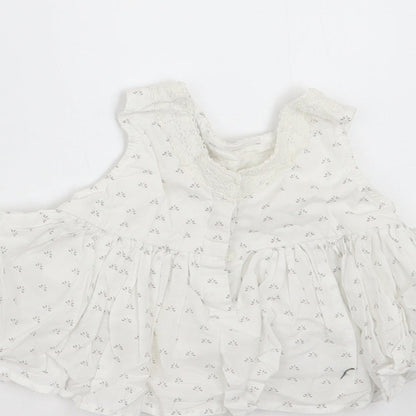 Brand and care label for Next girls’ white floral basic blouse, size 3-6, months