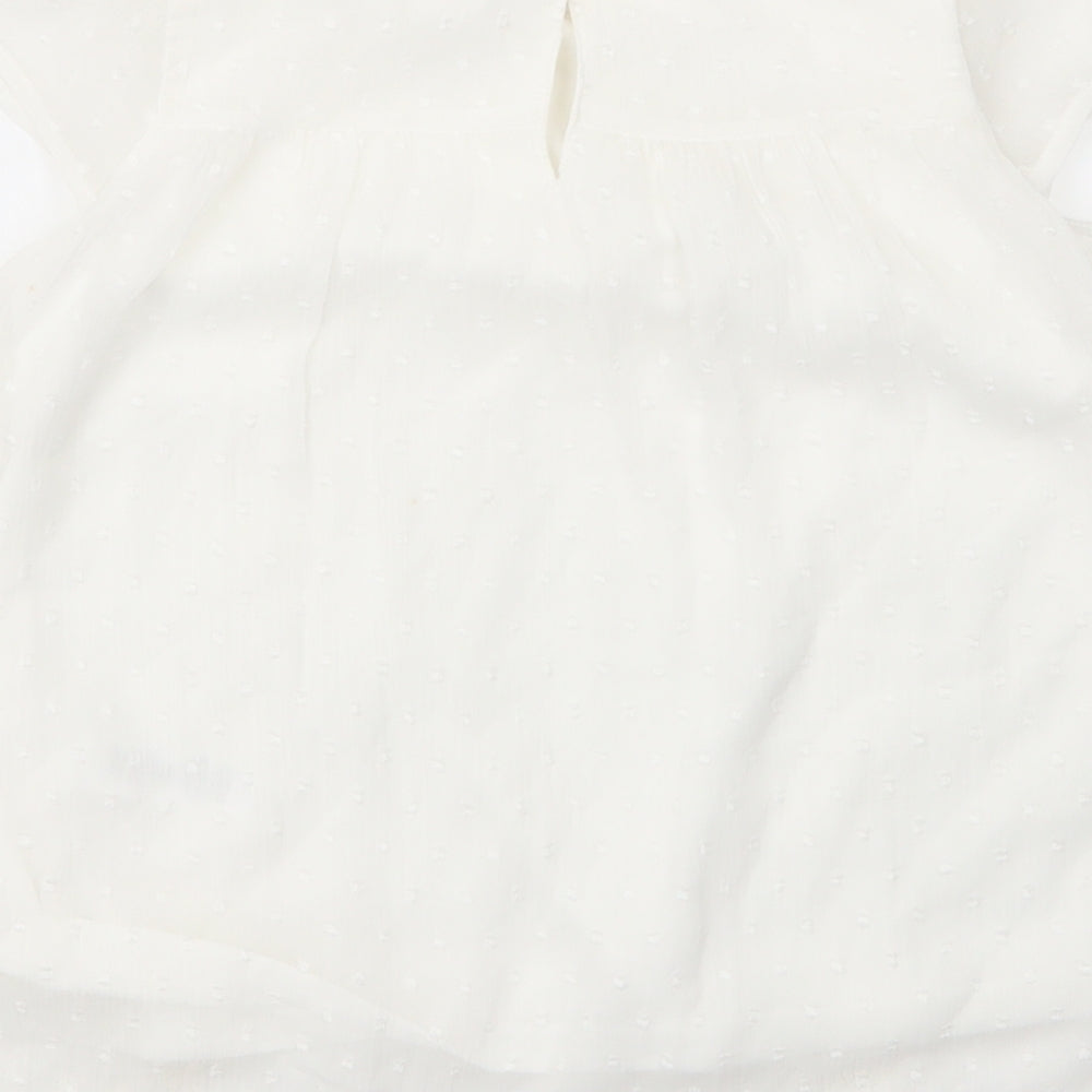 Brand and care label for George girls’ white nylon basic blouse, size 7, years round neck button