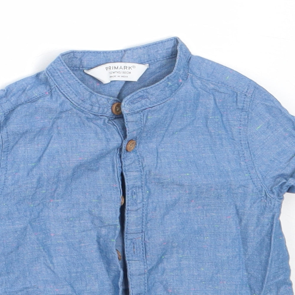 Close-up detail of Primark boys’ blue cotton basic button-up, size 9-12, months round neck