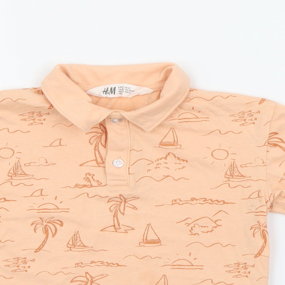 Close-up detail of H&M boys’ orange geometric cotton pullover polo, size 3, years collared button