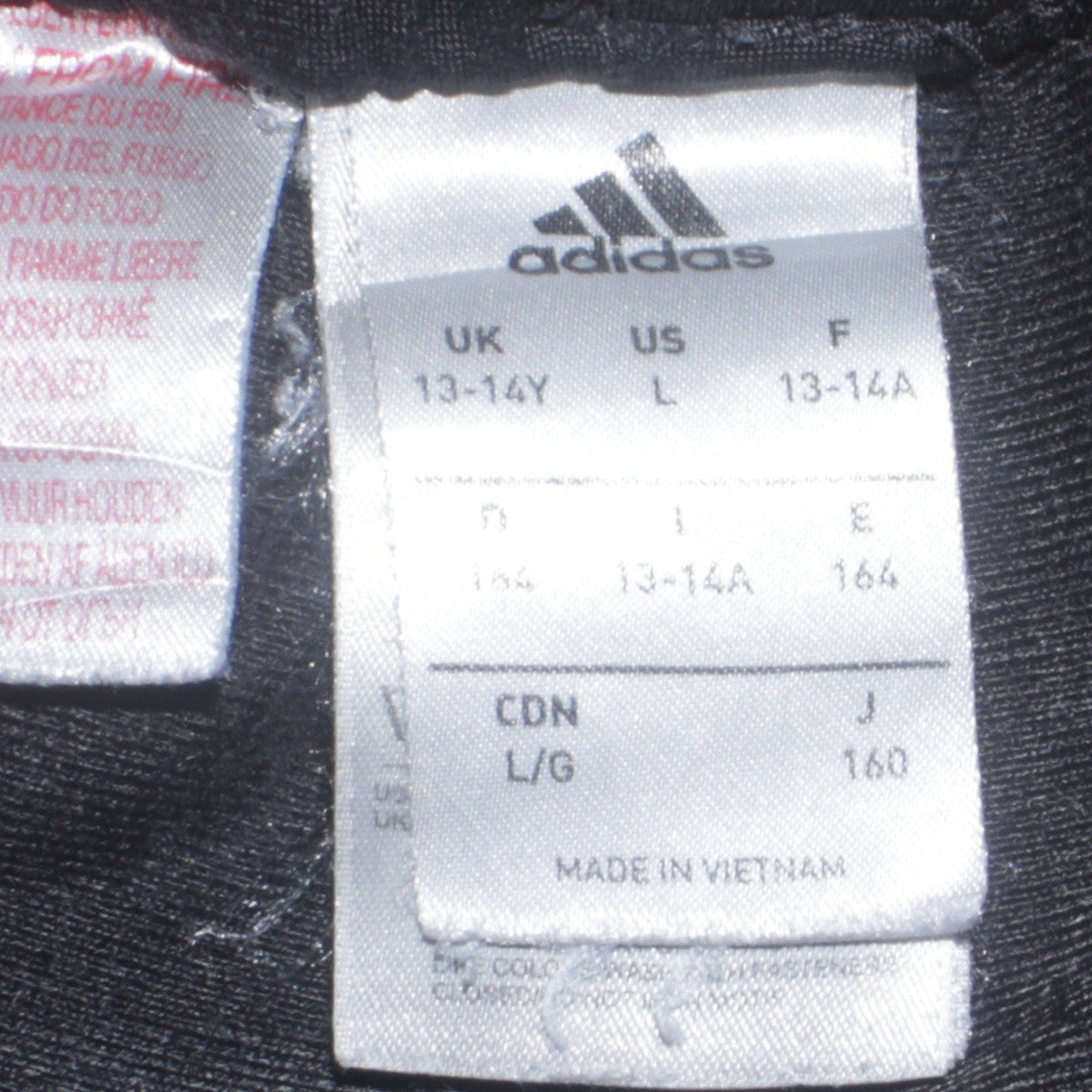 Close-up detail of adidas boys’ black 13-14 years track pants tapered fit sports trousers