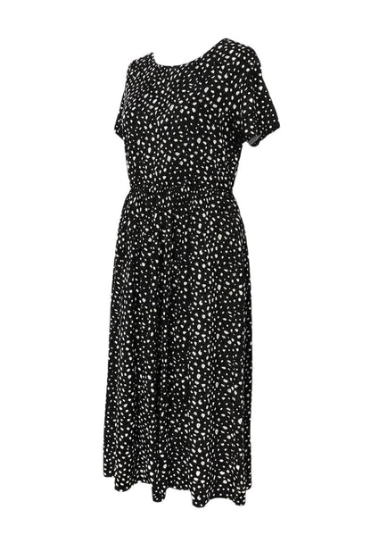 Prewornwholesale Wednesday's Girl black midi dress with white floral print, short sleeves, and A-line silhouette.